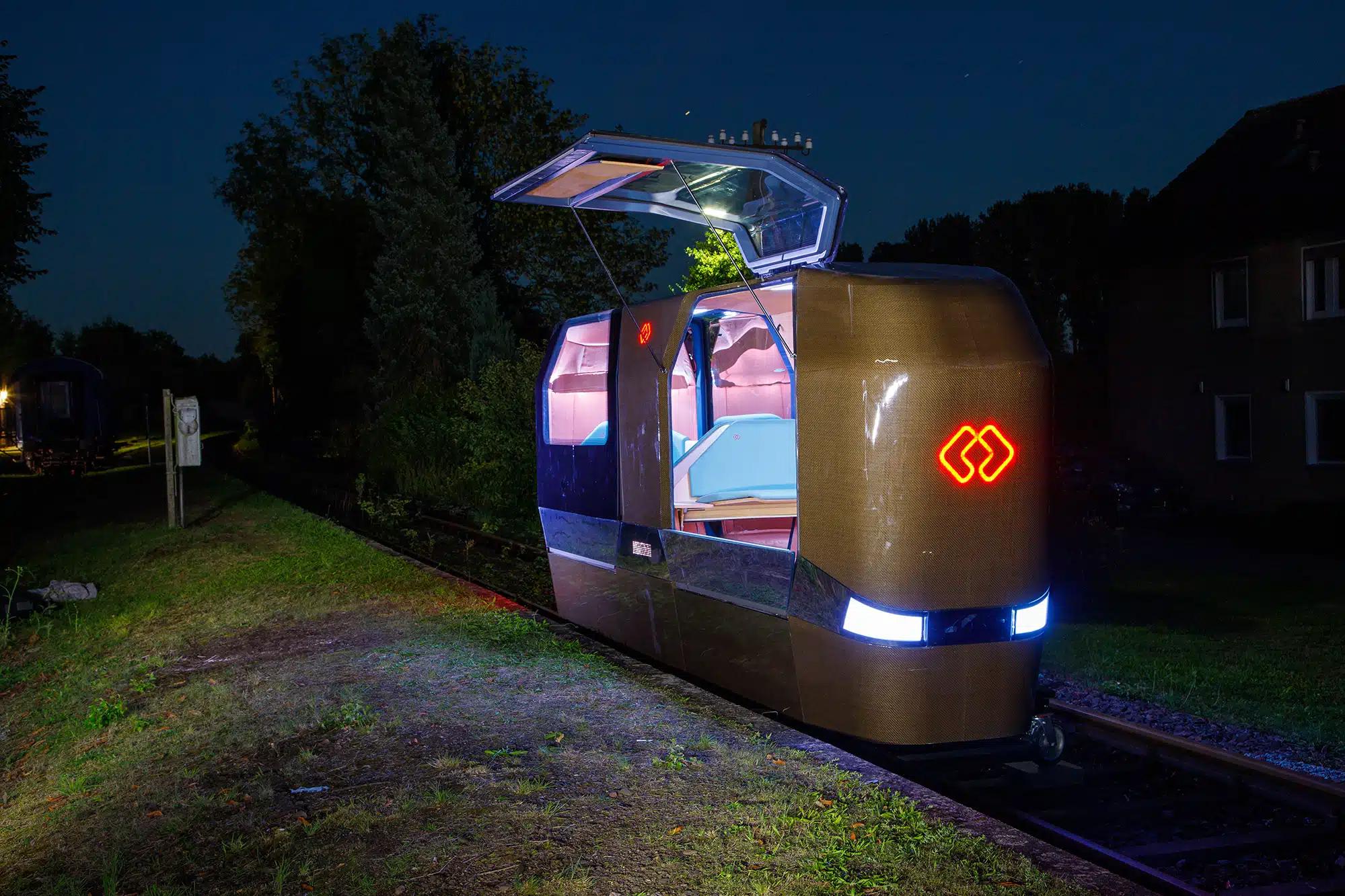 Selbstfahrende Kabine auf Schienen bei Nacht, die einem kleinen Zug-Wagon ähnelt