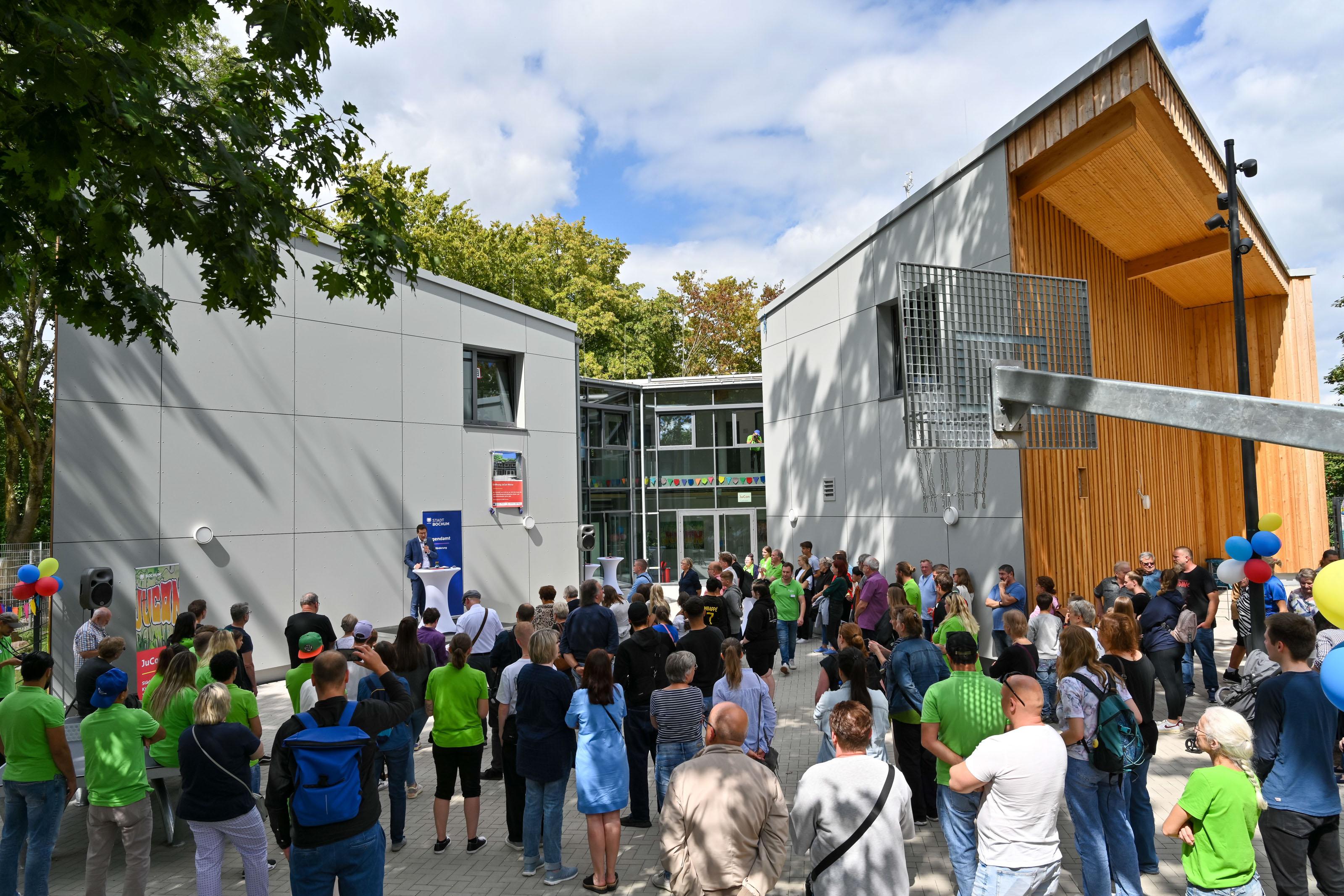 Es sind viele Leute vor einem Gebäude abgebildet. Es wird eine Rede vom Oberbürgermeister  gehalten.