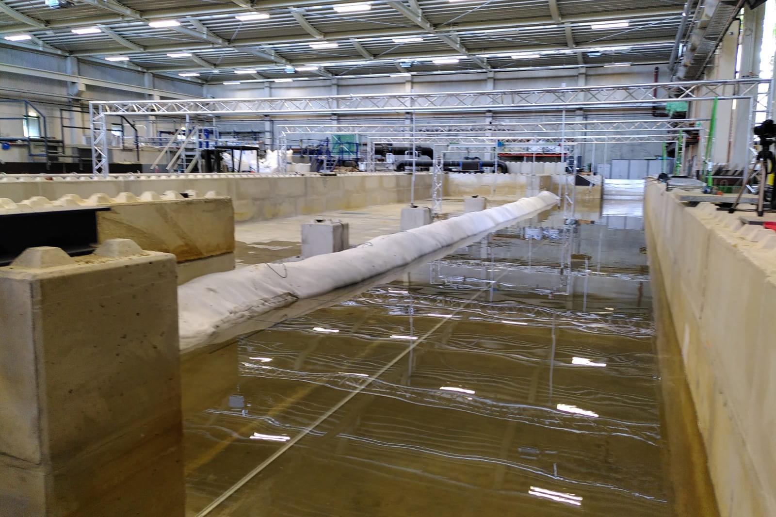 Es ist eine Halle von innen zu sehen, in der Wasser auf dem Boden ist.