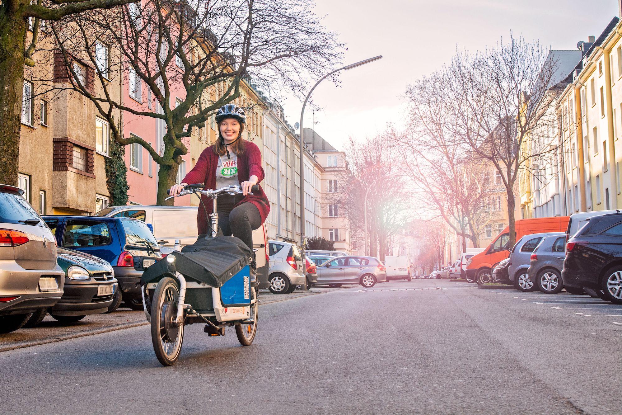 Frau radelt auf einem Lastenrad.