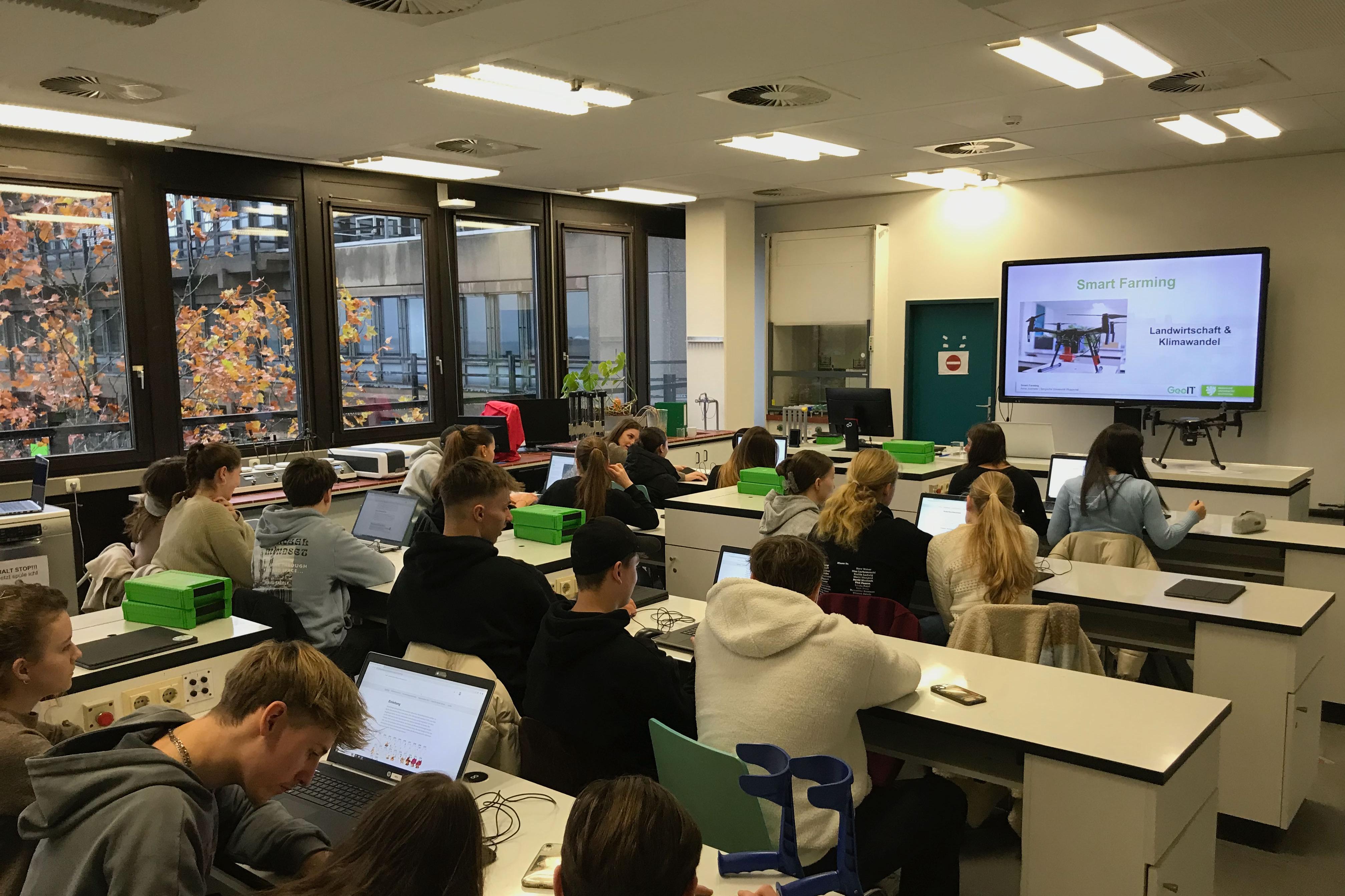 Im Klassenraum arbeiten die Schülerinnen und Schüler an ihren Laptos.