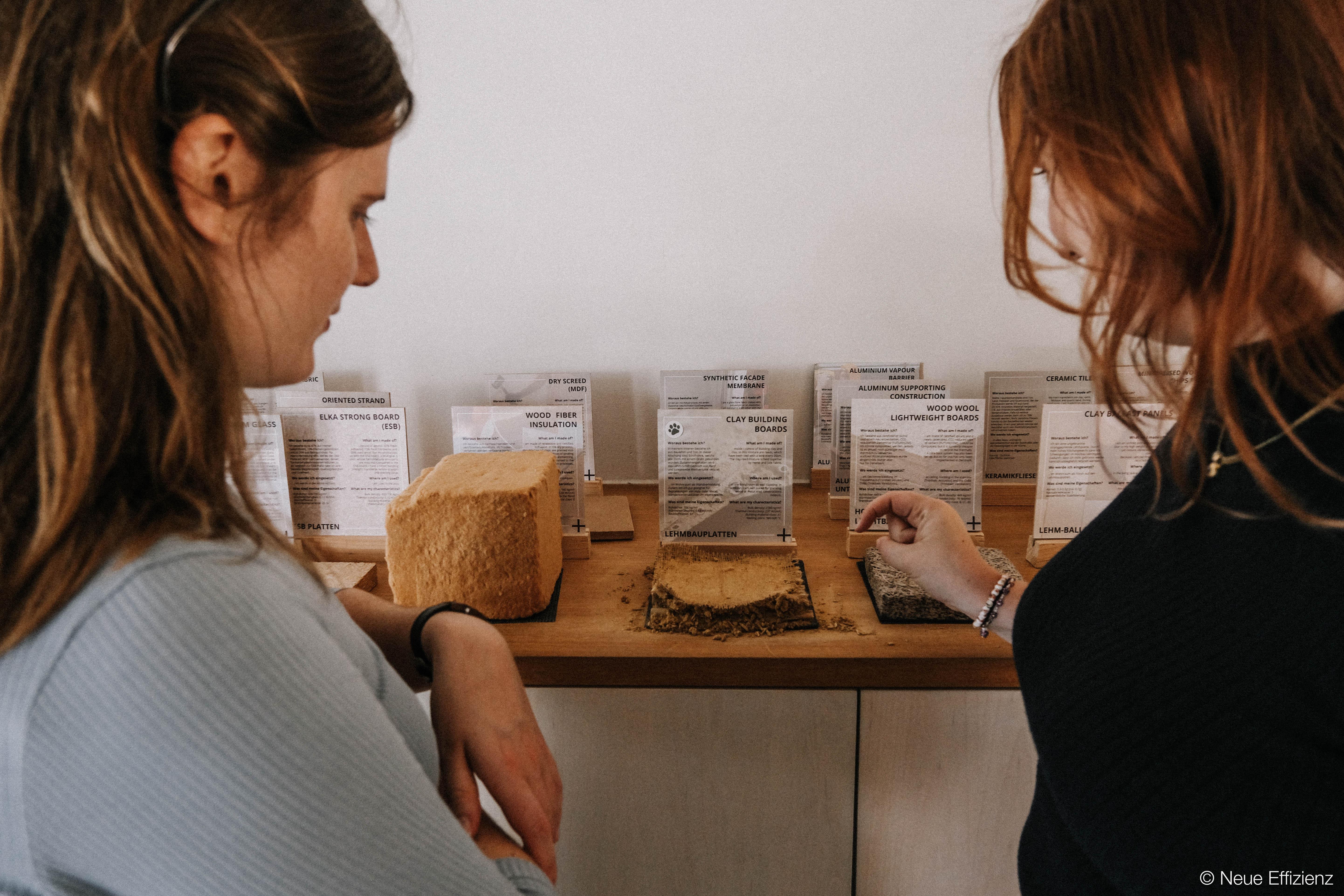 Zwei Persnen betrachten alternative Baumaterialien.