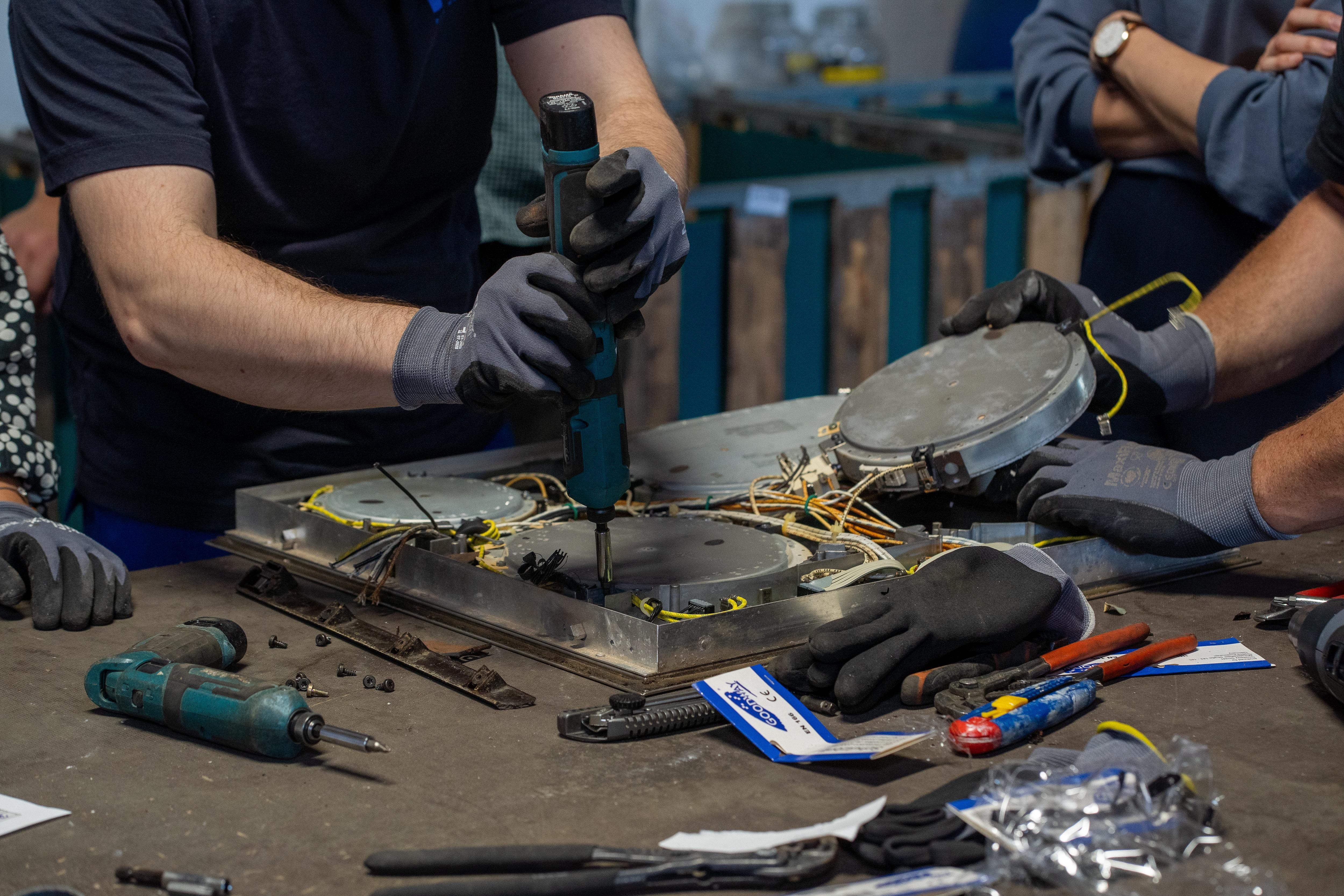 Mehrere Personen bauen Kochfelder auseinander.