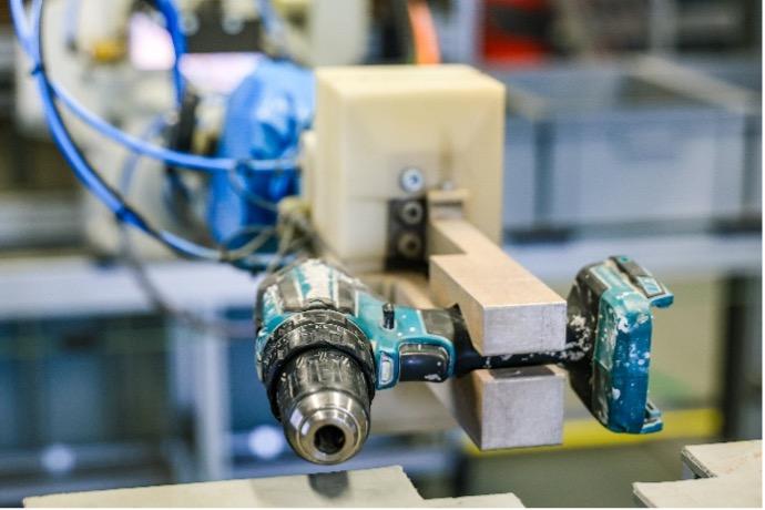 Eine Bohrmaschine wird von einem Maschinenarm gehalten. 