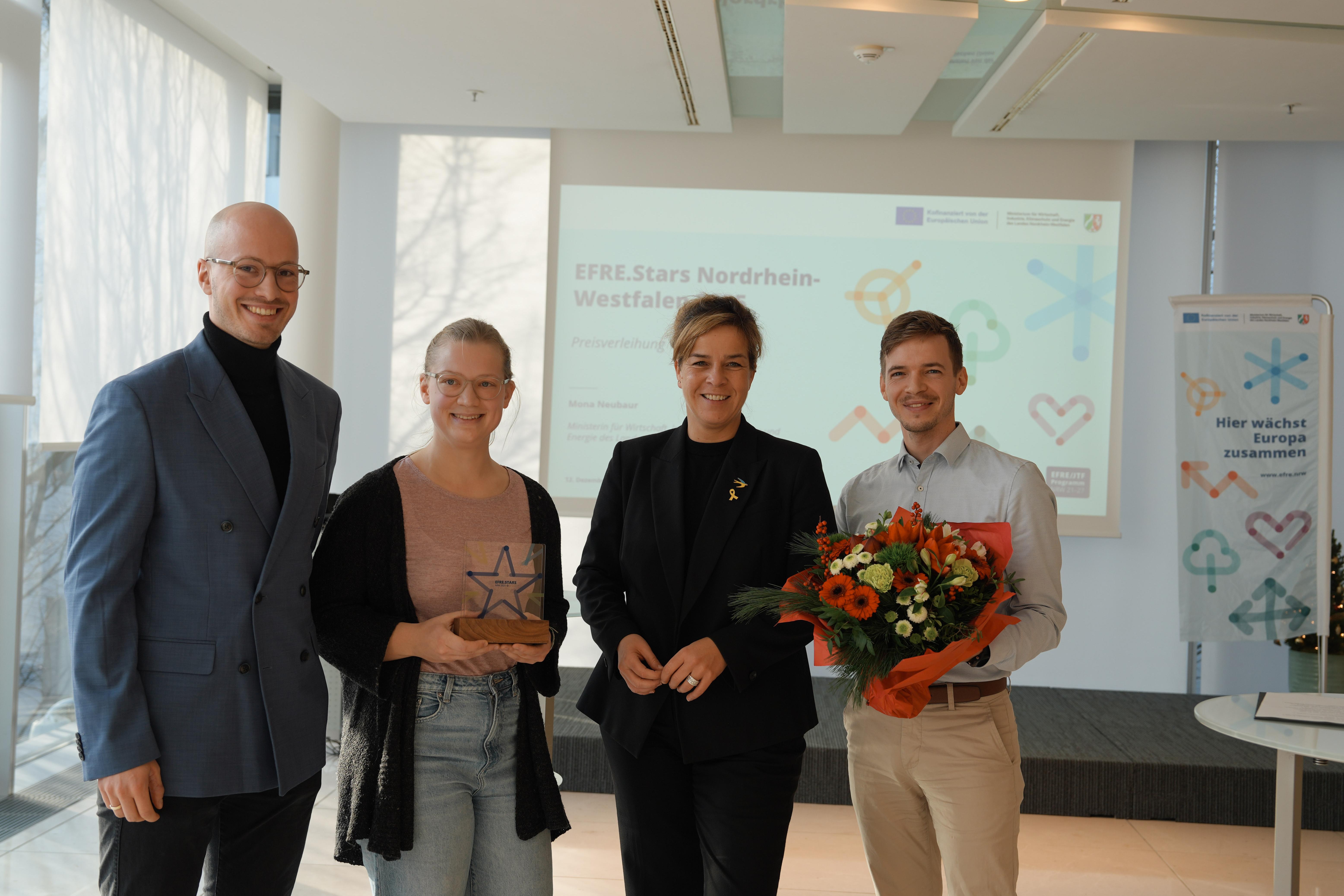 Vier Leute schauen lächelnd in die Kamera.