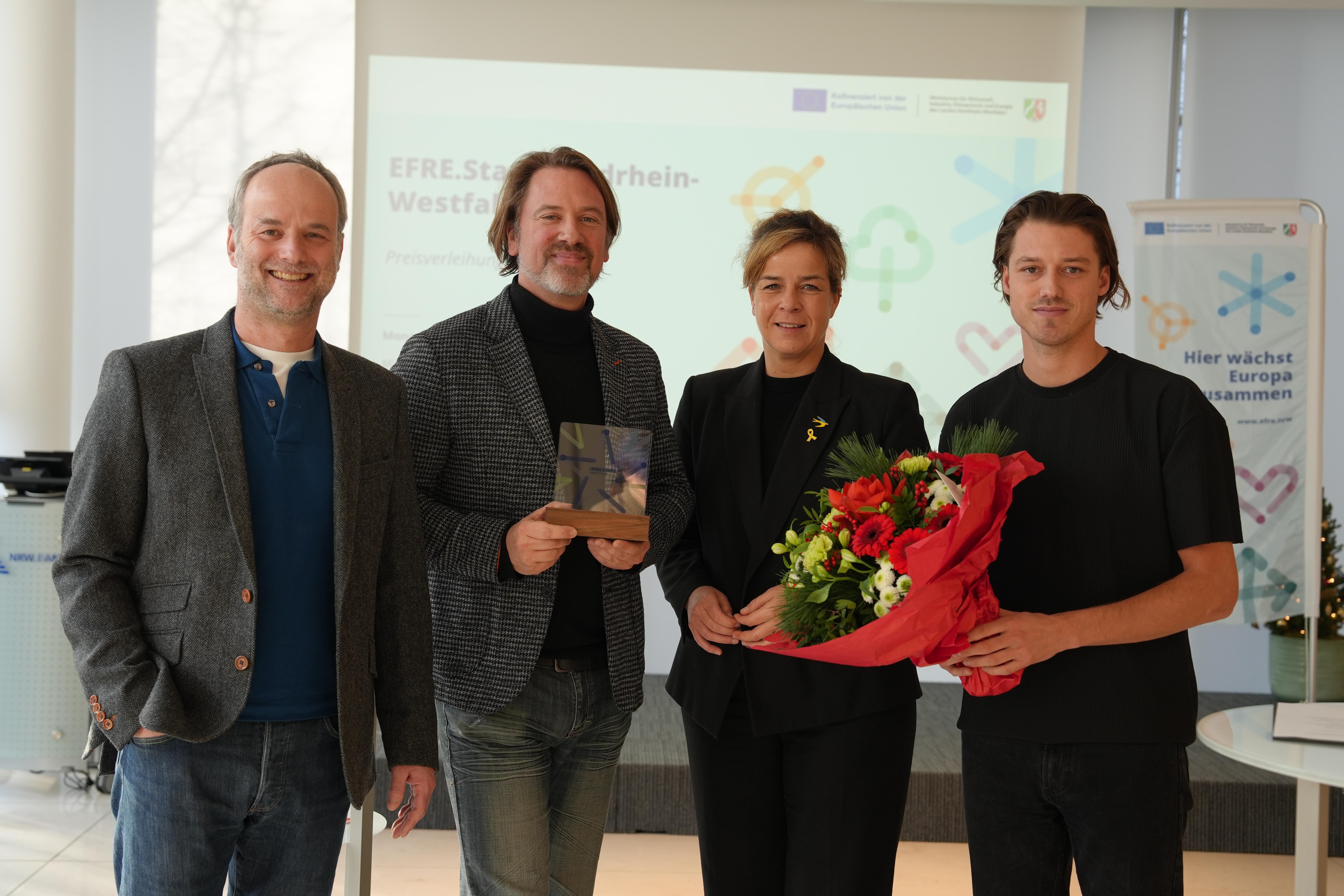 Vier Personen schauen lächelnd in die Kamera.