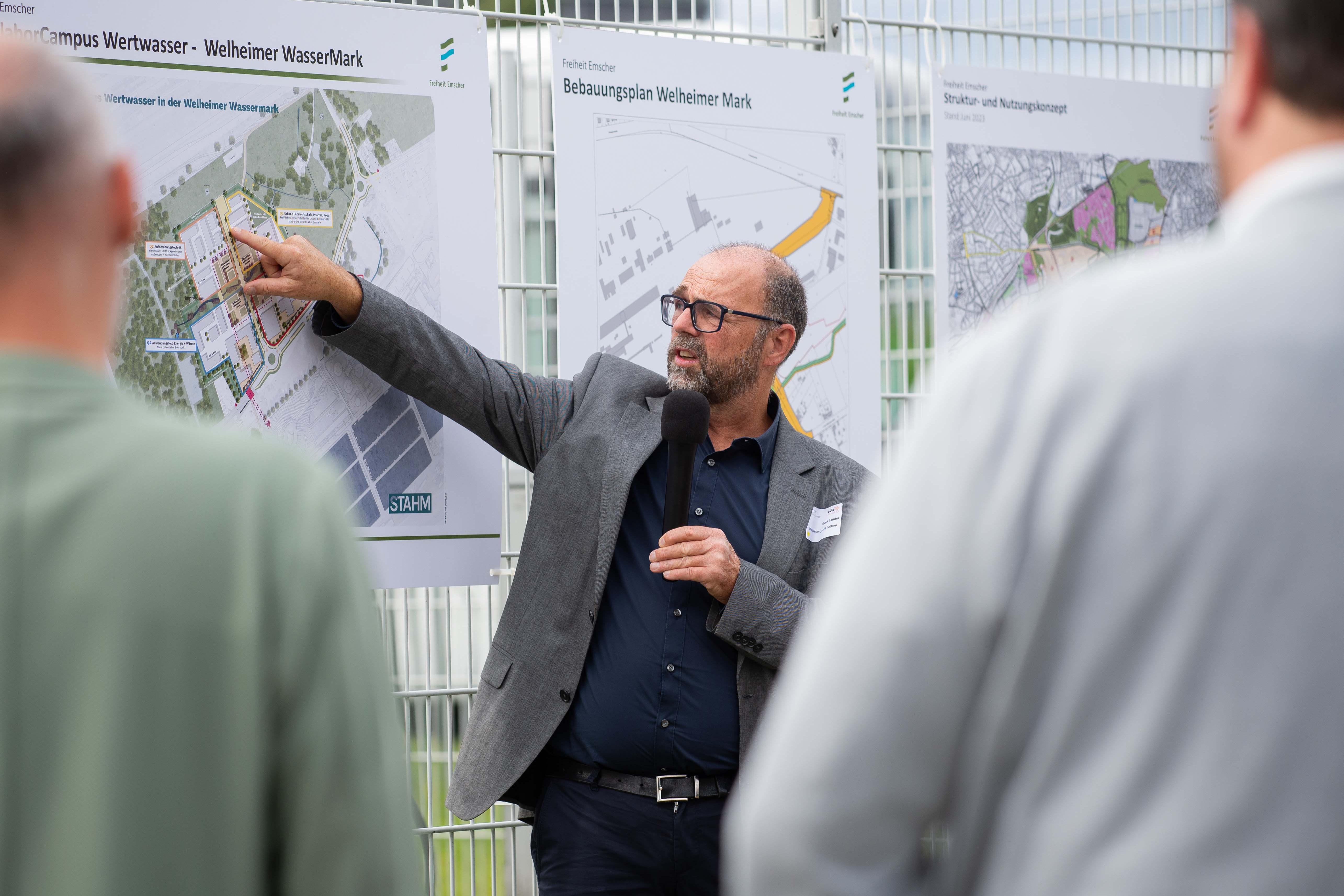 Ein Mann zeigt etwas auf einer Karte während andere zugucken.