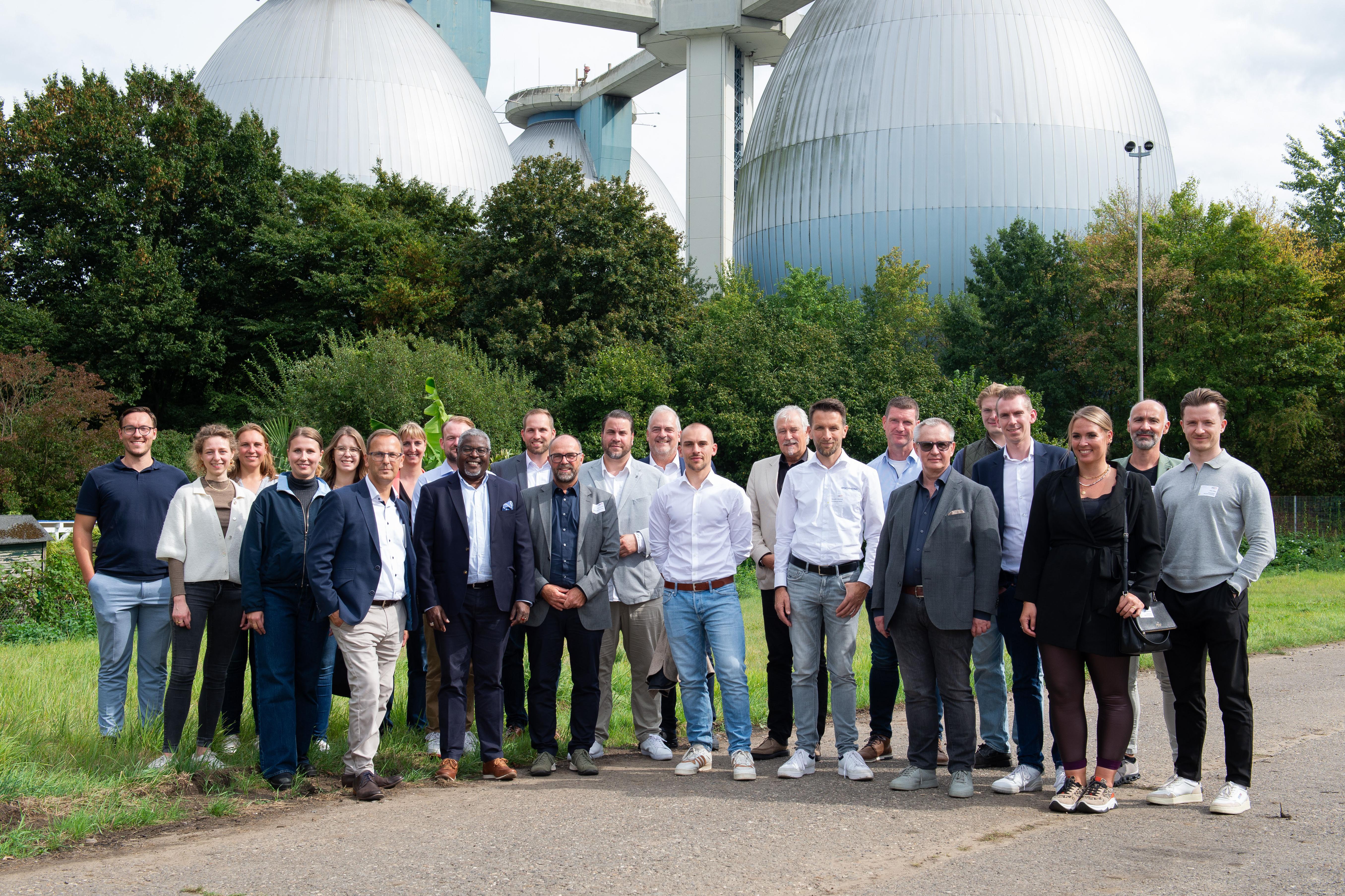 Eine Gruppe von Menschen posiert und lächelt vor der Kamera.