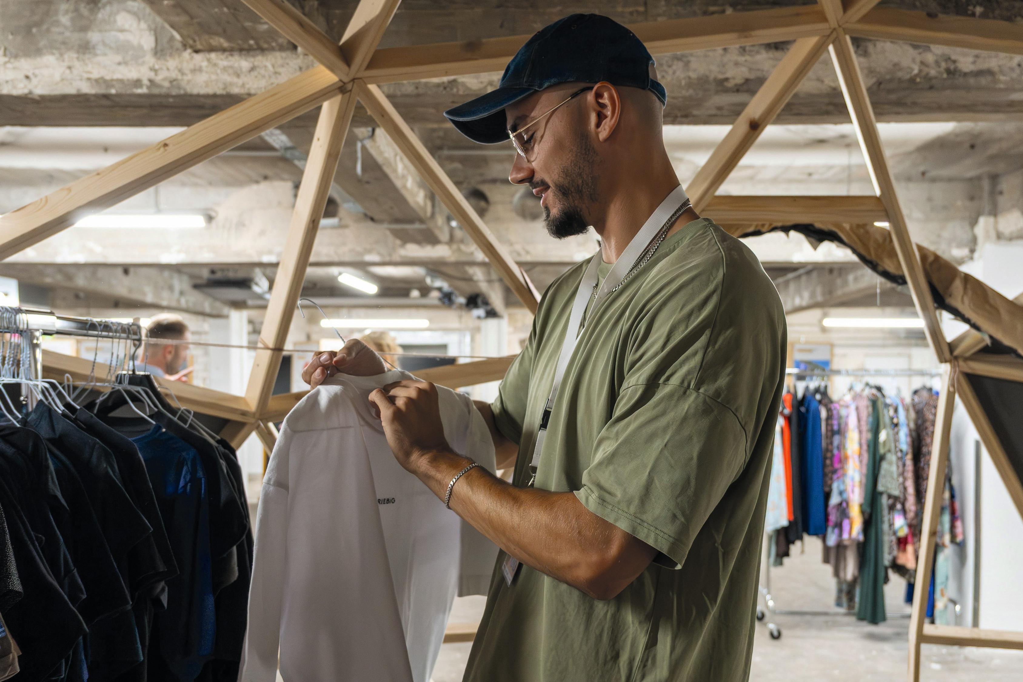Junger Mann schaut sich Kleidung an