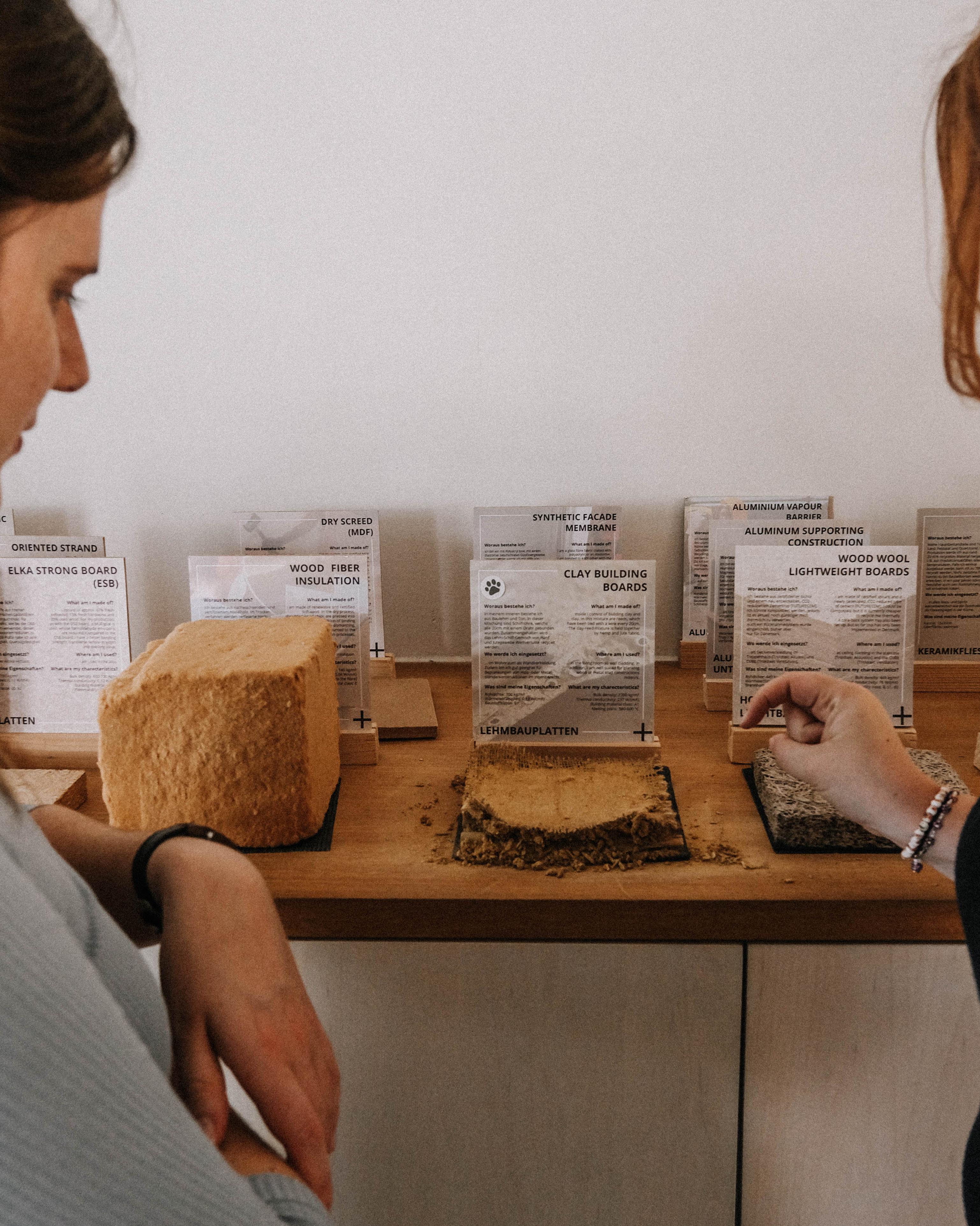 Zwei Persnen betrachten alternative Baumaterialien.