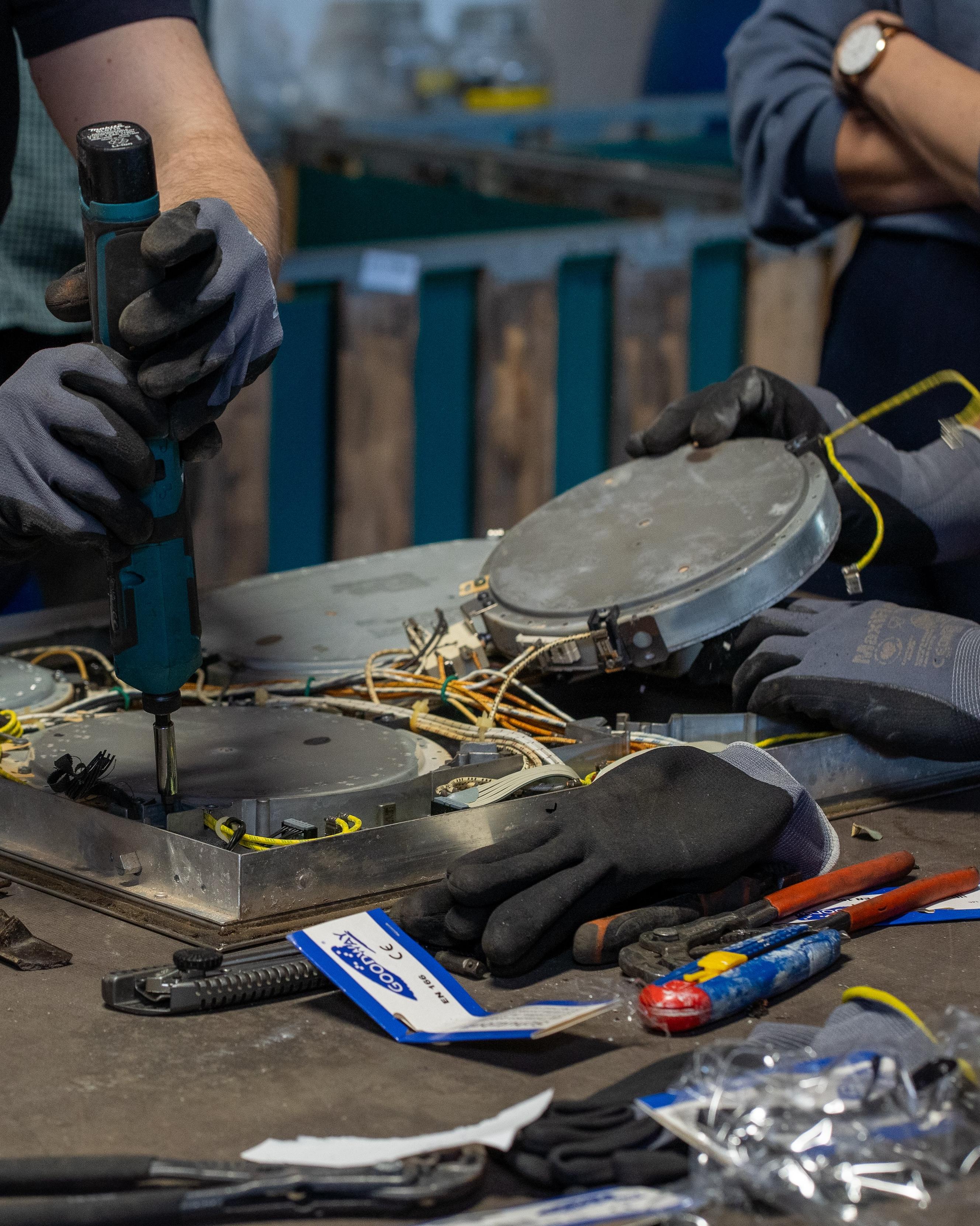 Mehrere Personen bauen Kochfelder auseinander.