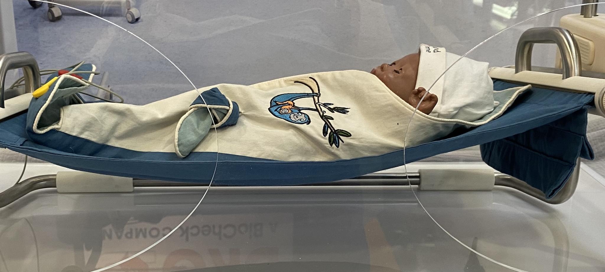 Puppe liegt in einem Brutkasten