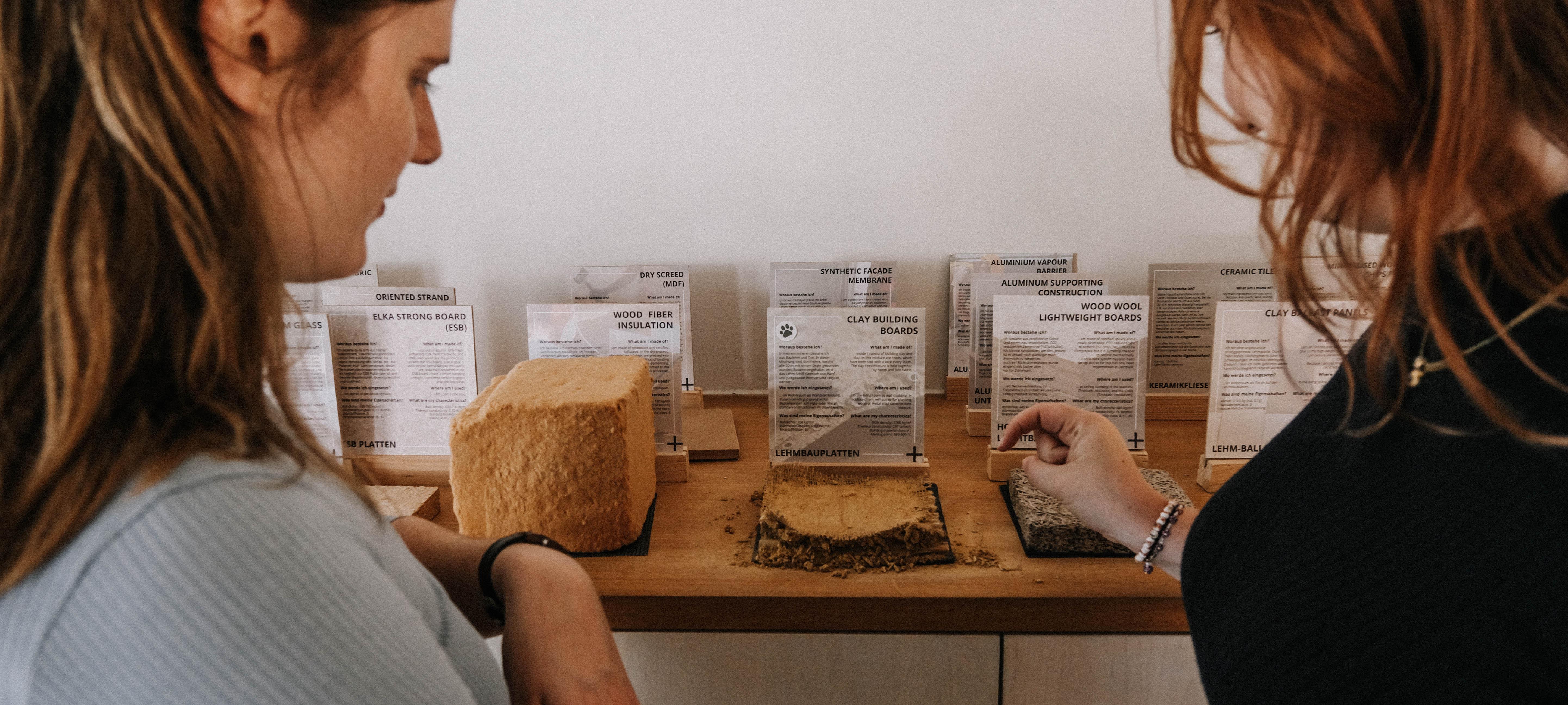 Zwei Persnen betrachten alternative Baumaterialien.